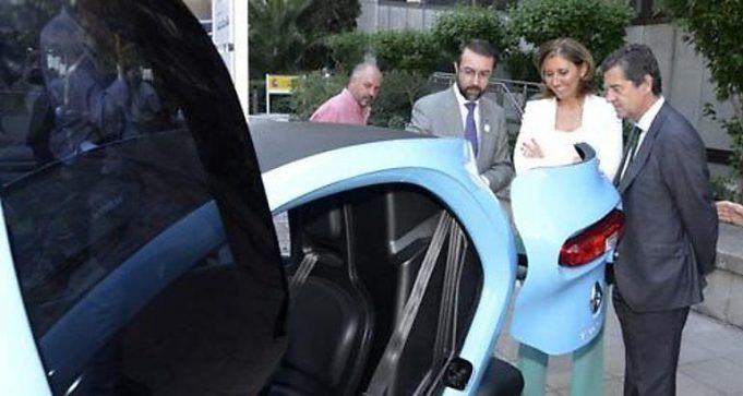 Representantes de Industria visitando un vehículo eléctrico