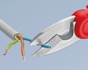 Tijera para electricista retirando protector de conductor