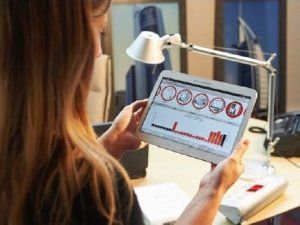 Mujer consultando una tableta android con datos de consumo eléctrico