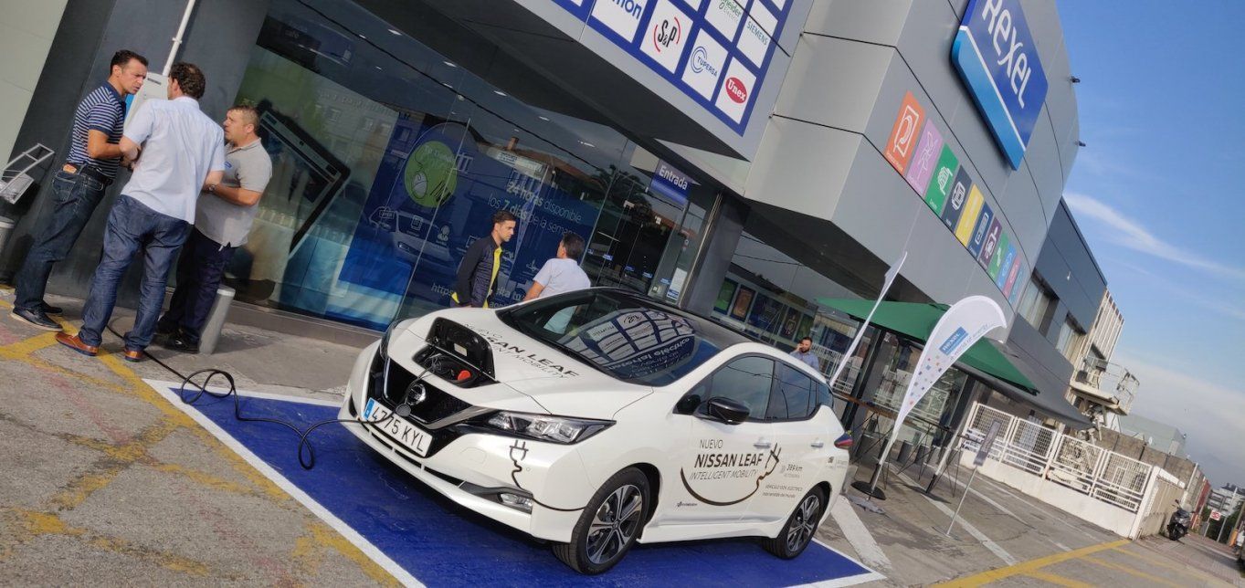 Un vehículo eléctrico Nissan Leaf cargando a la entrada del punto de Venta de Rexel en Coruña