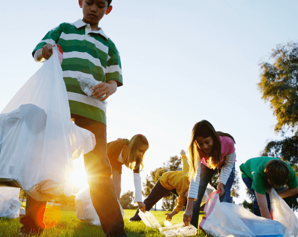 Niños recogiendo basura en un parque, dejemos un mundo mejor a nuestros hijos