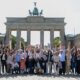Los participantes en la Convención Anual posan, con la Puerta de Brandenburgo de fondo